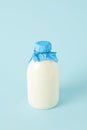 closeup shot of fresh milk in bottle wrapped by paper on blue background Royalty Free Stock Photo