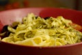 Closeup shot of fresh pasta with olives on red pot Royalty Free Stock Photo