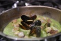 Closeup shot of freshly-made delicious mussel soup in a pot