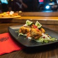 Closeup shot of fried mozzarella sticks with lime and salad in a black plate on the table Royalty Free Stock Photo