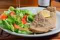 Closeup shot of fried veal cutlet Milanese with lemon and salad Royalty Free Stock Photo