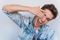 Closeup shot of funny handsome young man hiding his face with palms and show eye. Portrait of positive good-looking covering eyes Royalty Free Stock Photo