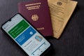 Closeup shot of a german digital green pass near a german passport and vaccination card Royalty Free Stock Photo