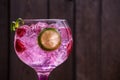 Closeup shot of gin tonic rose with raspberries and lime