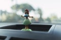 Closeup shot of girl figurine on a car dashboard