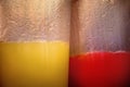 Closeup shot of glass cups filled with red and yellow drinks - great for a cool background Royalty Free Stock Photo