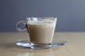 Closeup shot of a glass of half-drunk cinnamon chai latte on a wooden surface