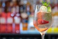 Closeup shot of a glass of iced cocktail with strawberries and cucumber on a bar counter Royalty Free Stock Photo