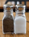 Closeup shot of glass salt and pepper shakers on a wooden background Royalty Free Stock Photo