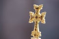 Closeup shot of a gold Armenian cross on a gray background Royalty Free Stock Photo