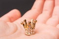 Closeup shot of a gold small crown on a person's palm