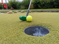 Closeup shot of a golf club pushing a ball into a hole