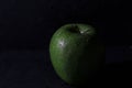 Closeup shot of a green apple on a black background Royalty Free Stock Photo