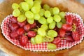 Closeup shot of green and red grapes lying on a checkered cloth Royalty Free Stock Photo