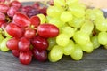 Closeup shot of green and red grapes lying on a wooden surface Royalty Free Stock Photo