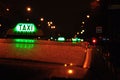 Closeup shot of the green sign on a taxi in Paris, France at night