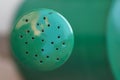 Closeup shot of a green watering can head with a blurry background Royalty Free Stock Photo