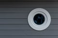 Closeup shot of a grey wooden wall with a small wooden white porthole Royalty Free Stock Photo