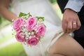 Closeup shot of the groom dragging the garter down the bride's leg under the wedding dress Royalty Free Stock Photo