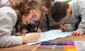 Closeup shot of a group of kids drawing together on the floor Royalty Free Stock Photo