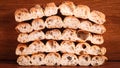 Closeup shot of half-sliced barbari bread pieces piled up against the brown wooden wall background