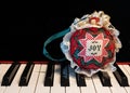 Closeup shot of a hand-stitched colorful Christmas ornament on a piano with a copy space Royalty Free Stock Photo
