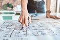 Closeup shot hand of a woman architect holding a pen and looking over plans, blueprints are schematics. One caucasian Royalty Free Stock Photo