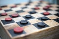 Closeup shot of a handmade wood checkers game with red and black squares
