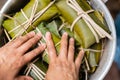 Closeup shot of hands making wrapped Honduran style tamales