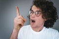 Closeup shot of handsome curly hair amazed handsome man has excited expression, look away, indicate finger up to advertisement Royalty Free Stock Photo