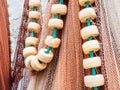 Closeup shot of hanging multicolored fishing nets and white beads on a green rope Royalty Free Stock Photo