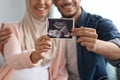 Closeup shot of happy pregnant muslim couple demonstrating baby sonography photo