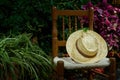 Closeup shot of a hat on a decorative chair on a background of plants