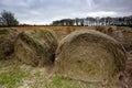 Closeup shot of hay bales in the field under the dark cloudy sky Royalty Free Stock Photo