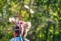 Closeup shot of the head of a person in a traditional Indian-American festive hat with feathers