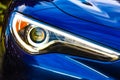 Closeup shot of a headlight of a blue modern car