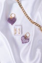 Closeup shot of heart shaped beaded keychains with a pair of earrings and a gold chain