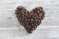Closeup shot of a heart-shaped figure with coffee beans on a wooden background Royalty Free Stock Photo