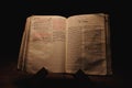 Closeup shot of a historic old Bible open on the St. John pages on display in a dark room