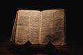 Closeup shot of a historic old Bible open on the Thessalonians pages on display in a dark room