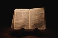 Closeup shot of a historic old Bible open on the Thessalonians pages on display in a dark room