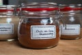 Closeup shot of a chili powder in a jar on the table with two other jars in the blurred background Royalty Free Stock Photo
