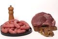 Closeup shot of homemade sausages with pepper and raw meat isolated on a white background Royalty Free Stock Photo