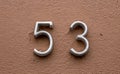 Closeup shot of a house number fifty-three on the wall surface Royalty Free Stock Photo