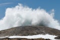 Closeup shot of huge brown sea stone and wave splash