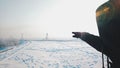 Closeup shot of a human pointing a place in a snowy landscape