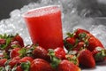 Closeup shot of icy strawberry smoothie in a plastic cup on background of ice cubes and strawberries Royalty Free Stock Photo