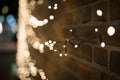 Closeup shot of illuminated string lights covering the wall of a building at night