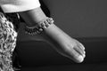 Closeup shot of Indian girl child ankle bracelet isolated on bare feet