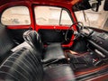 Closeup shot of the interior of a red little Fiat 500 with leather seats